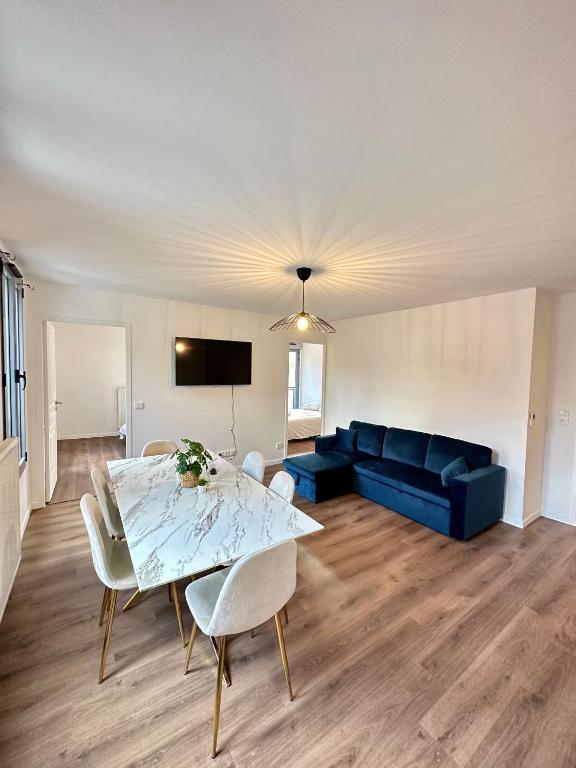 a living room with a table and a blue couch at Magnifique apartment in Paris / Bagnolet 101 in Bagnolet