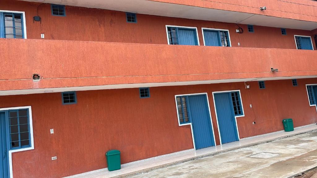 a red building with blue doors and windows at Hotel Ikawa in La Loma