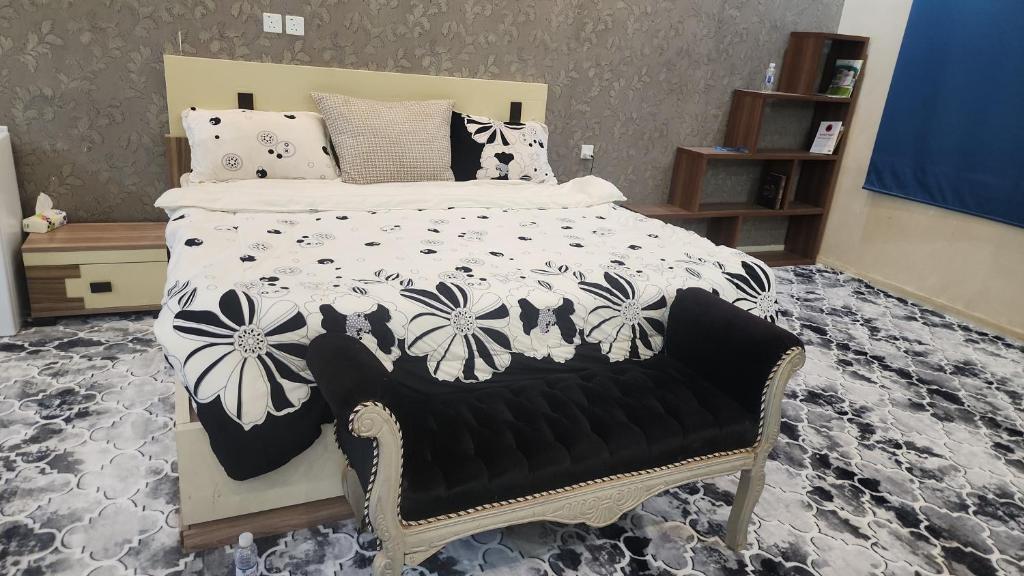 a bedroom with a bed with a black and white comforter at مزرعة واستراحة بستان in Şāmitah