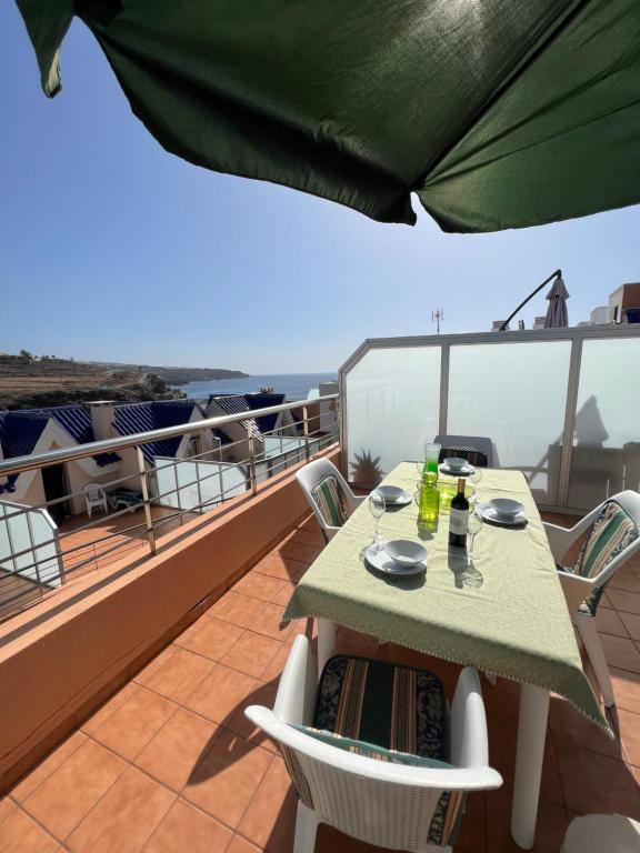 een tafel en stoelen op het balkon van een schip bij Apartamentos Playa San Juan Tenerife in Playa de San Juan