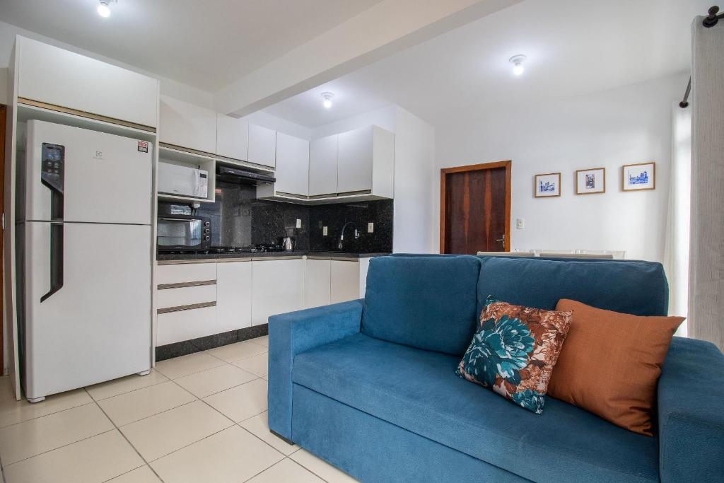 ein blaues Sofa im Wohnzimmer mit Küche in der Unterkunft JOA21 - 2 Dorm, Climatizado, Wi-Fi, Garagem in Balneário Camboriú