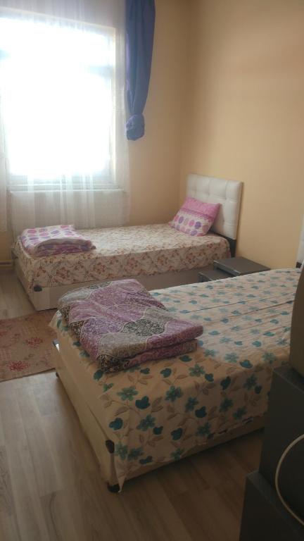 a room with three beds and a window at Çiftlik otel 
