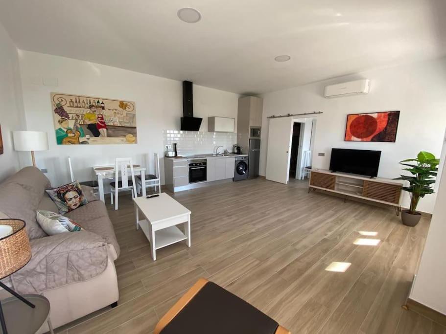 uma sala de estar com um sofá e uma cozinha em Sea Escape 2 em Almuñécar