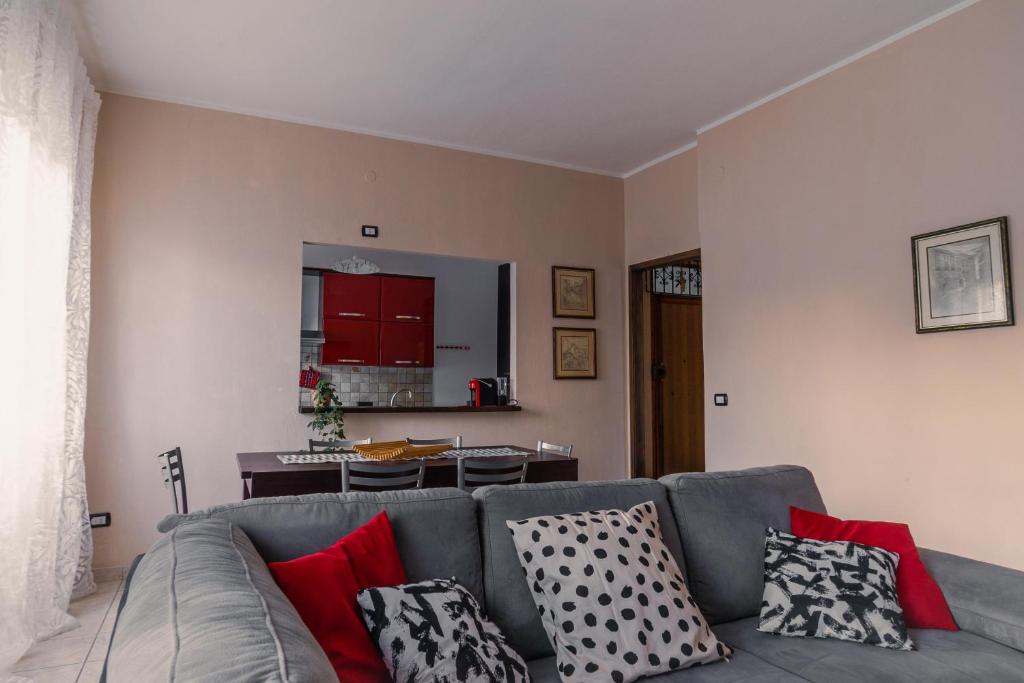 uma sala de estar com um sofá cinzento com almofadas em Il Vicoletto em Iglesias