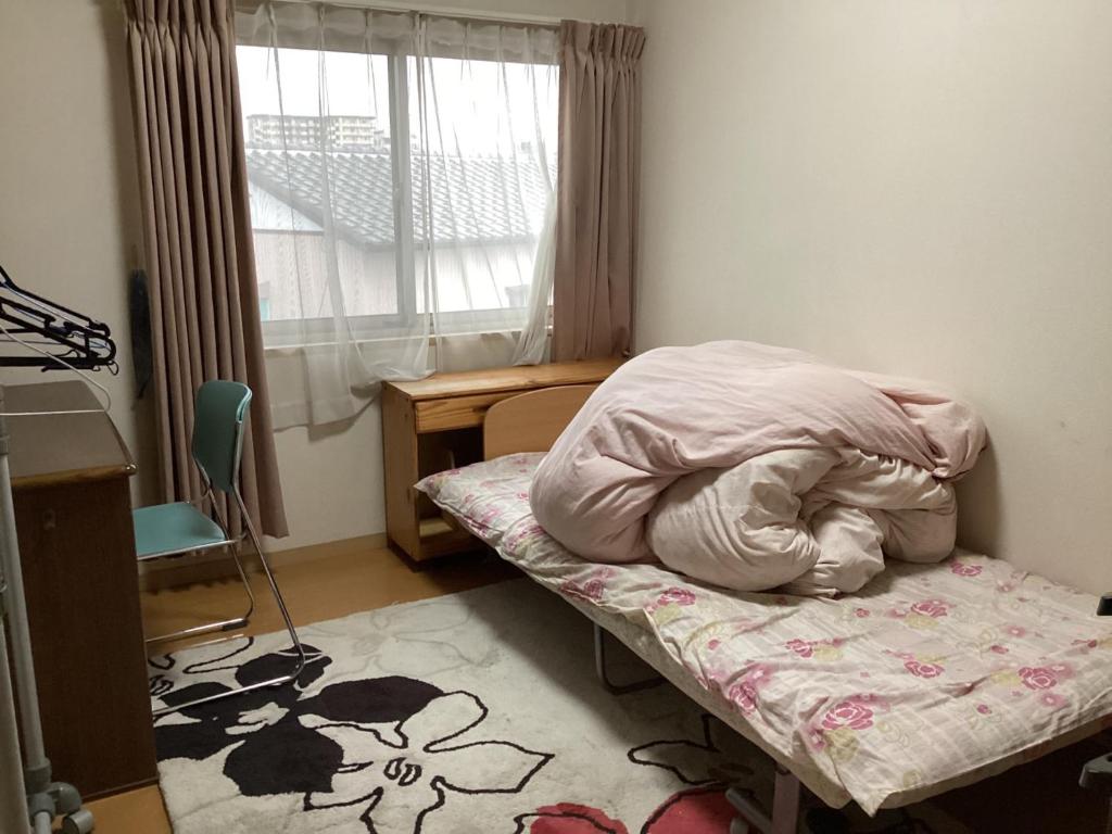 een kleine kamer met een bed en een raam bij ichihara homestay-stay with Japanese family - Vacation STAY 15787 in Ichihara