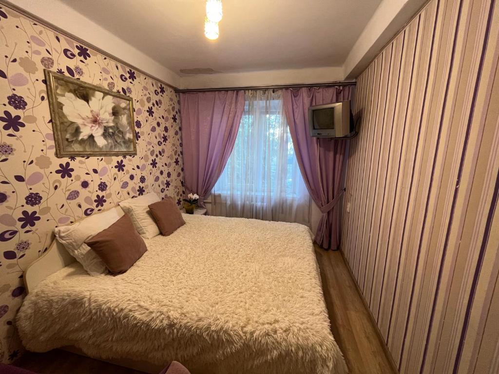 a small bedroom with a bed and a window at 2-на квартира вул. Михайла Донця 5, поруч НАУ, КПІ, клініка Шалімова, метро Шулявська -15 хв in Kyiv