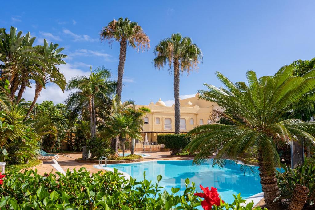 un complejo con palmeras y un edificio en Villas y Apartamentos El Sultan, en Corralejo