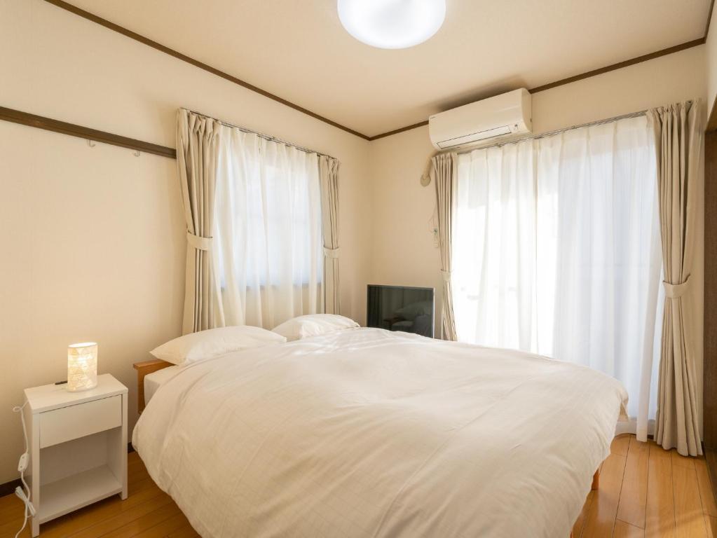 - une chambre avec un lit blanc et une fenêtre dans l'établissement maison elegance - Vacation STAY 15799, à Tokyo
