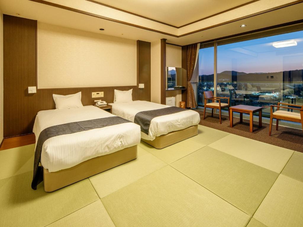 Habitación de hotel con 2 camas y balcón en TennenOnsen Hinatanoyado Nichinan Miyazaki - Vacation STAY 18655v, en Nichinan