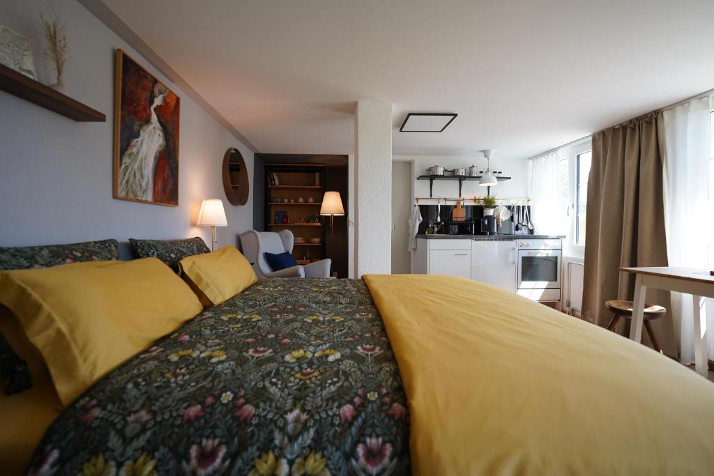 una camera con un letto con una coperta gialla di Bergnestli a Oberegg