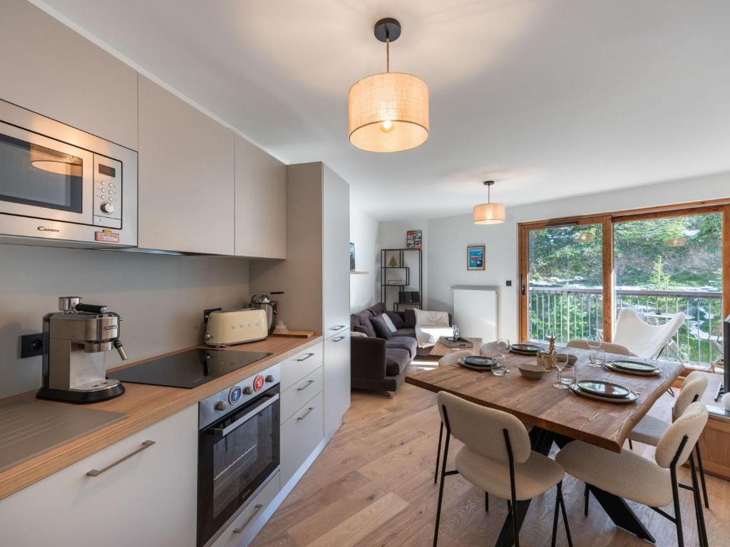Il dispose d'une cuisine et d'un salon avec une table en bois et une salle à manger. dans l'établissement Appartement récent, proche des pistes avec balcon et parking à Courchevel - FR-1-563-138, à Courchevel