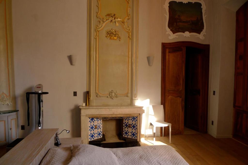 a bedroom with a fireplace and a mirror on the wall at Luxury two bedroom apartment in Apt, the heart of the Luberon in Apt