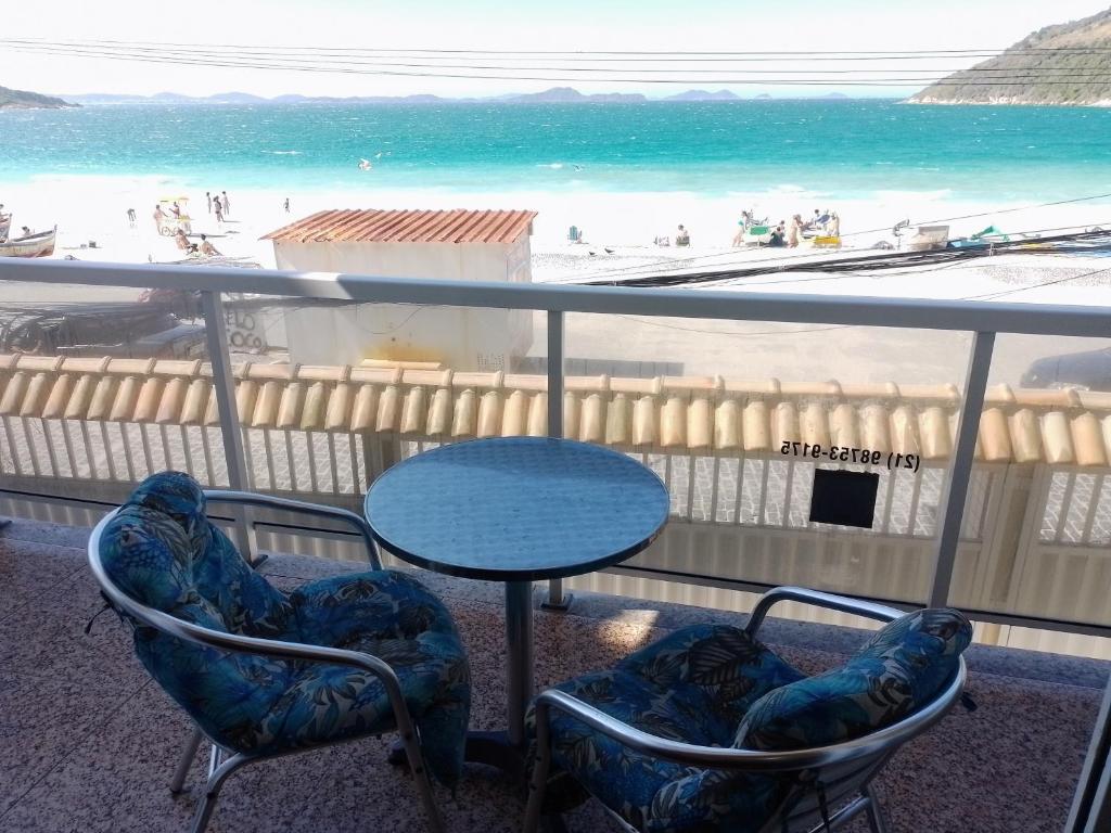 balcón con mesa y sillas y la playa en Frente Mar! Apto 3 Quartos de Frente para Prainha!, en Arraial do Cabo