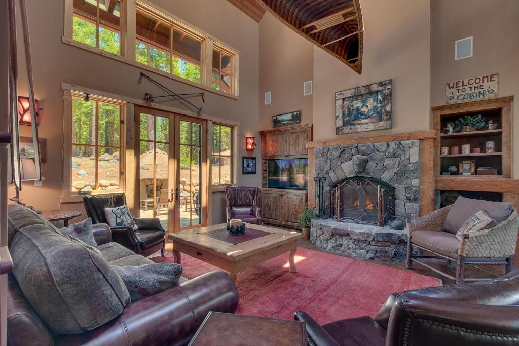 uma sala de estar com mobiliário de couro e uma lareira de pedra em New Listing! West Shore Bliss - 4BR, Private Hot Tub em Tahoe City