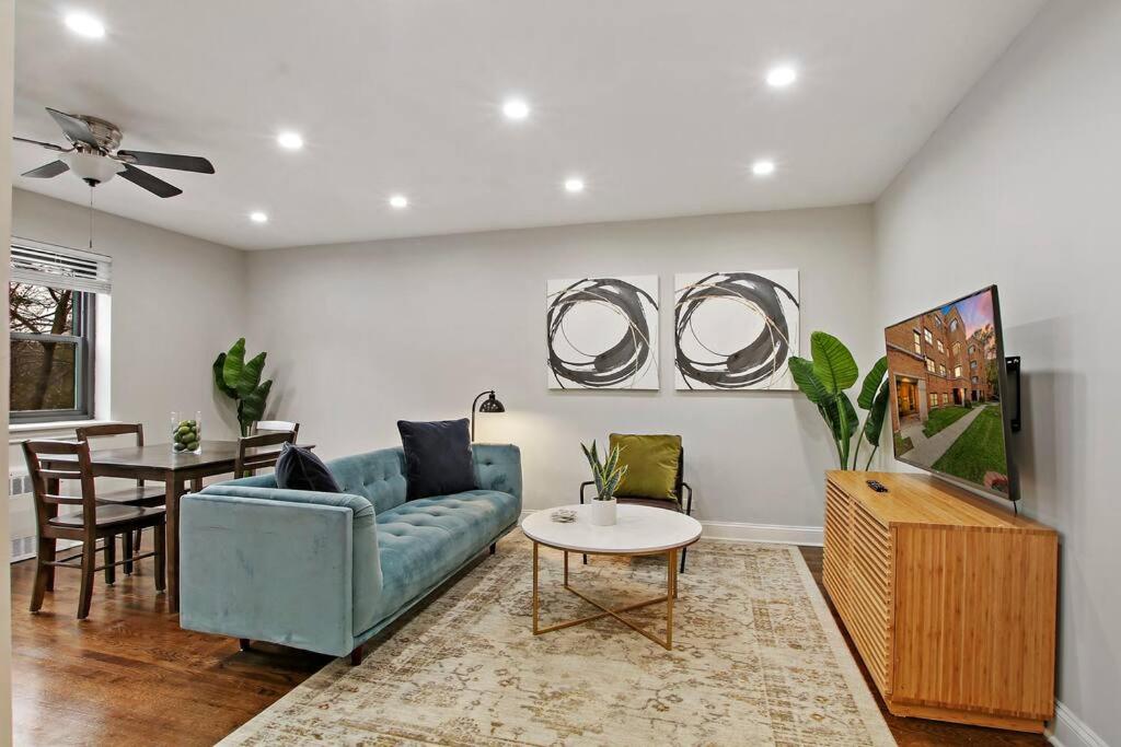a living room with a blue couch and a table at 2BR Roomy & Stylish Apartment in Rogers Park - Sheridan N2 in Chicago