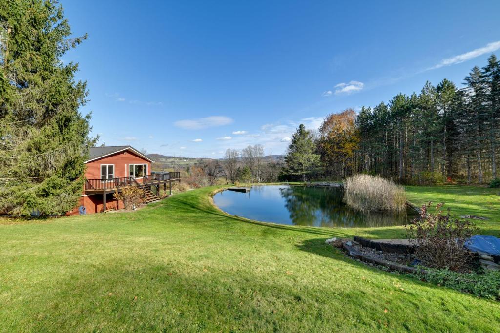 a home with a pond in the yard at Spacious Finger Lakes Home with Mountain Views 