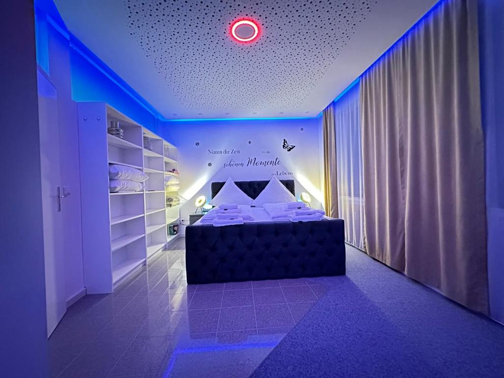 um quarto com uma cama num quarto com luzes azuis em Modern Apartments Neuburg 1 - TOP NEU - 2 Zimmer, Komfort, Zentrum, Wi-Fi, Smart TV, Stellplatz, Küche em Neuburg an der Donau