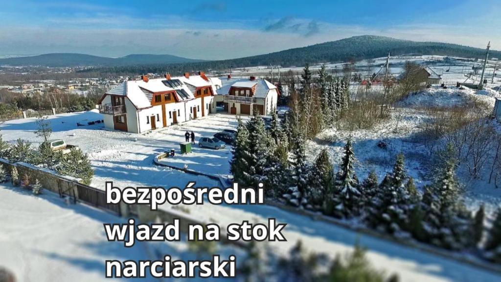 una casa en la nieve con las palabras woked mi mazapán enfermo en Apartamenty Pod Łysicą & SPA - przy stoku, basen, jacuzzi, sauna, en Krajno Pierwsze