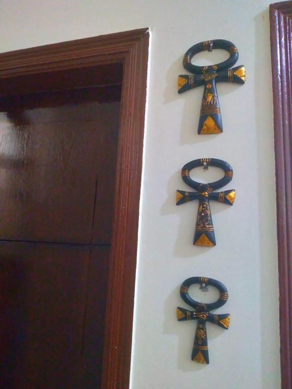 three ties hanging on a wall next to a door at Mooody nobin haws in Abu Simbel