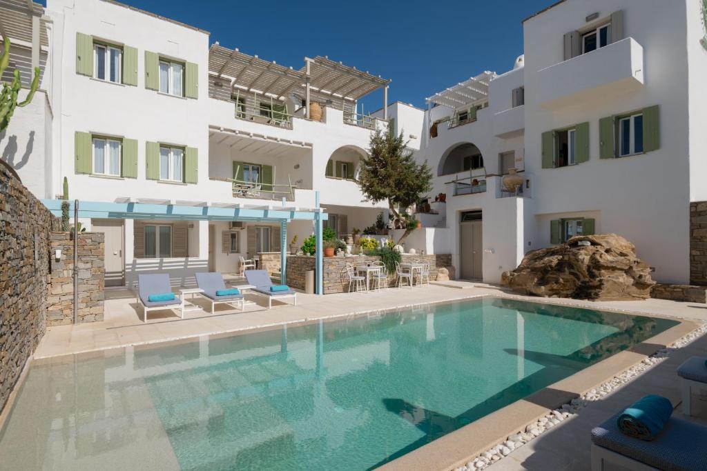 a swimming pool in front of a building at Anthos Apartments in Naousa