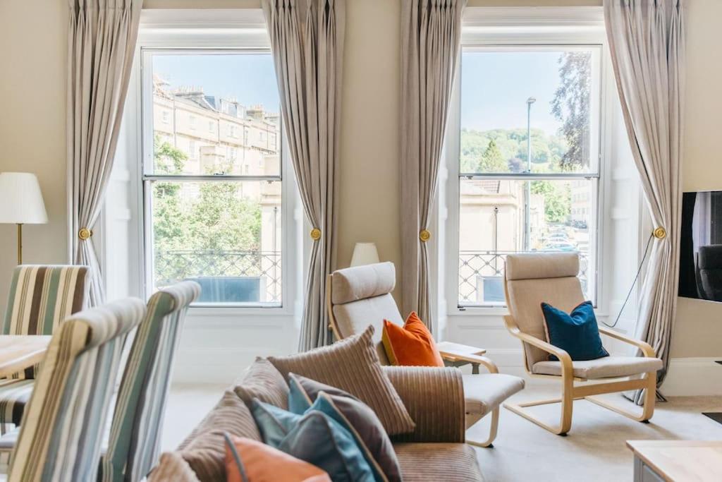 a living room with a couch and two windows at Luxury, Central, Sun-Filled 3 Bed Haven in Bath in Bath