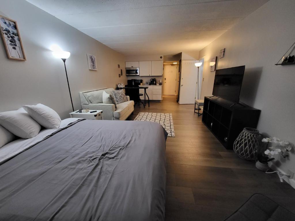 a bedroom with a bed and a living room at Cedar Lodge Condo with Lake Winnipesaukee Views; close to Weirs Beach!! in Laconia