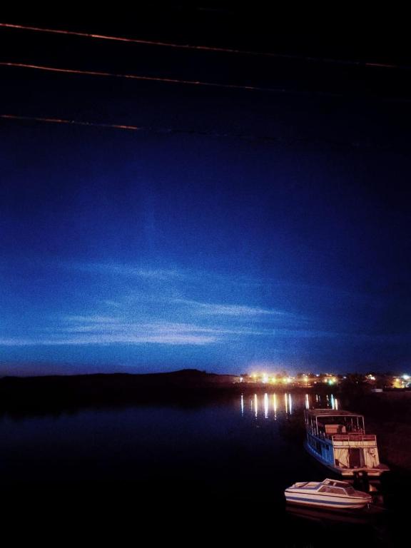 a boat sitting on the water at night at Mooody nobin haws in Abu Simbel