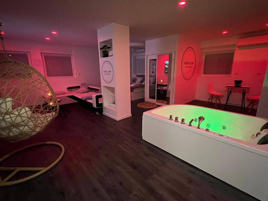 Cette chambre aux murs roses comprend une baignoire. dans l'établissement Metz Détente Un Séjour à Part, à Metz