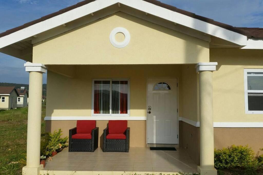 two red chairs on a porch of a house at Cabaña Papaya: 3br 2bth Retreat!! in Falmouth