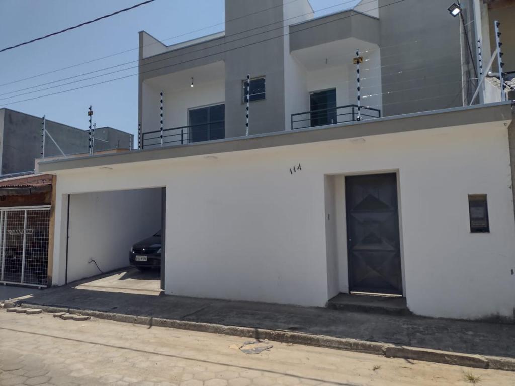 阿帕雷西達的住宿－Casa próxima ao Santuário de Aparecida，前面有一辆汽车停放的白色建筑