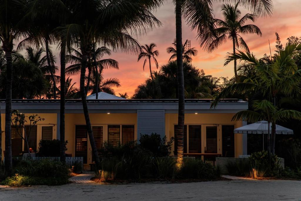 a house with palm trees in front of a sunset at Islander Resort in Islamorada