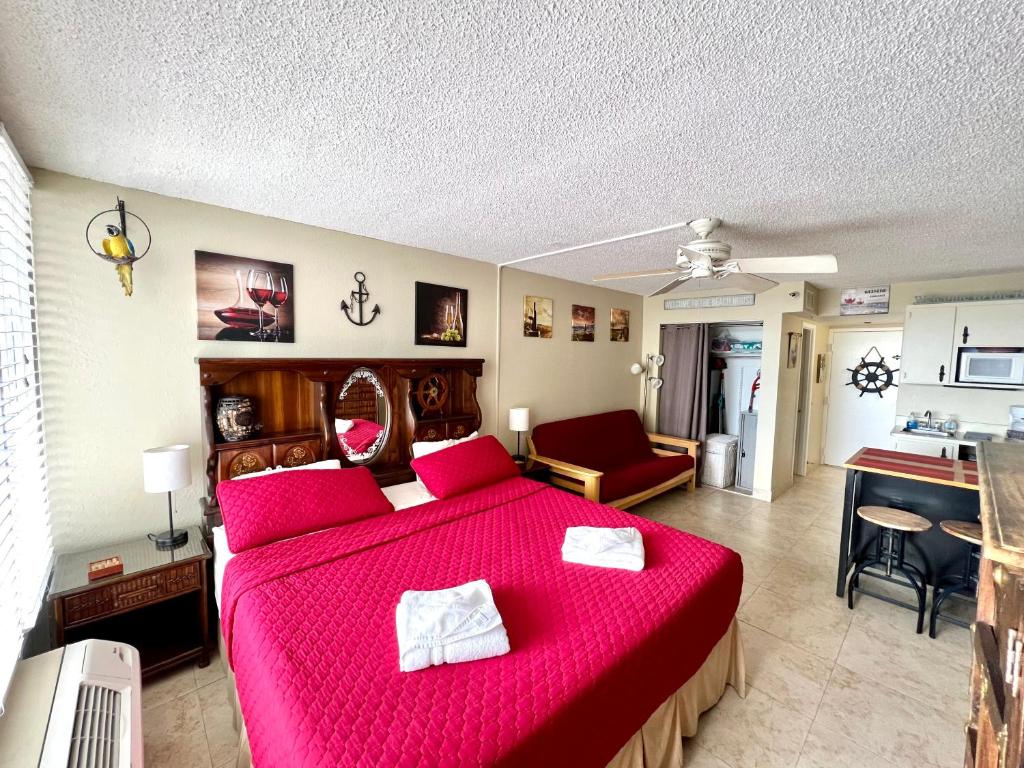 - une chambre avec un lit rouge et un salon dans l'établissement Wine-y Beach 7th Floor Ocean View King Bed, à Daytona Beach Shores