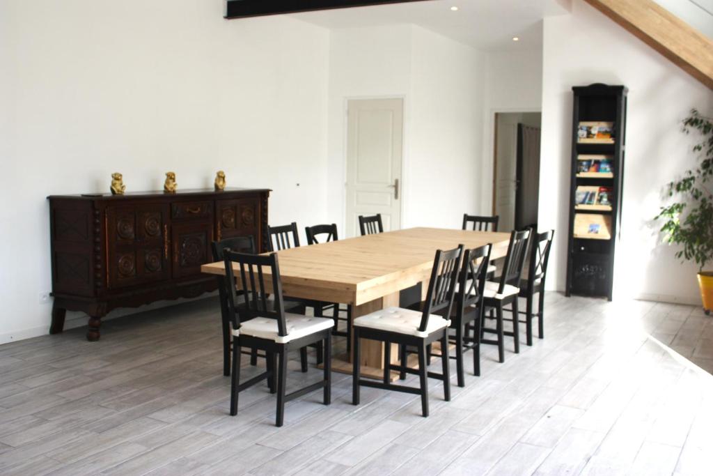 uma sala de jantar com uma mesa de madeira e cadeiras em Ti Guernevez em Briec