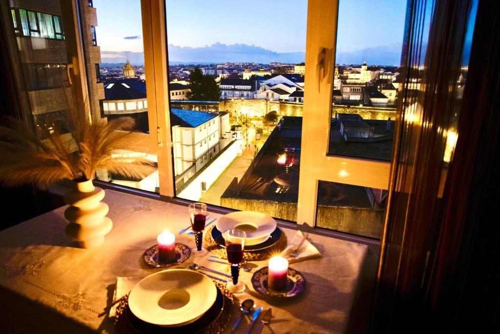 a table with candles and a view of a city at Muralla & Views by Lugo Collection in Lugo