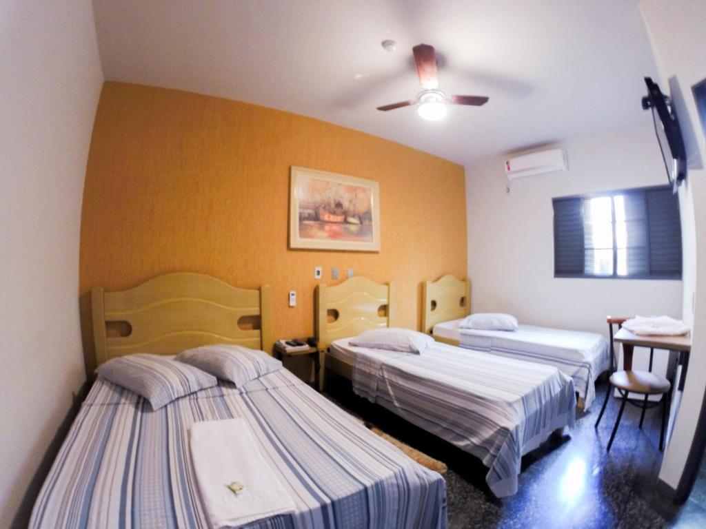 a hospital room with two beds and a table at Hotel Graunas in São Carlos