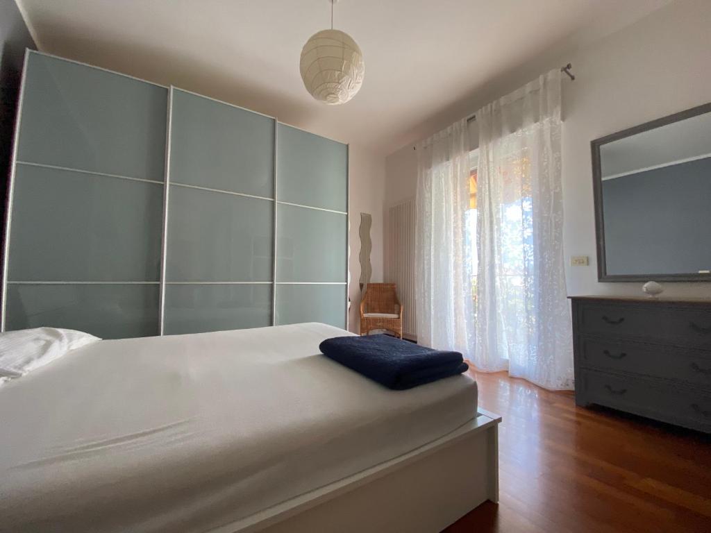 a bedroom with a large white bed with a tv on the wall at BellAria Bliss Relax a 10 Minuti dal Cuore di Bologna con parcheggio privato in Bologna