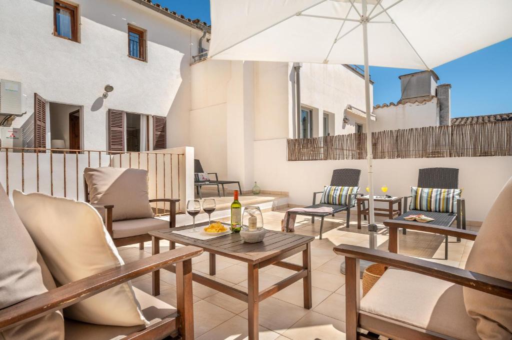 a patio with chairs and tables and an umbrella at Ca na Francesca in Pollença