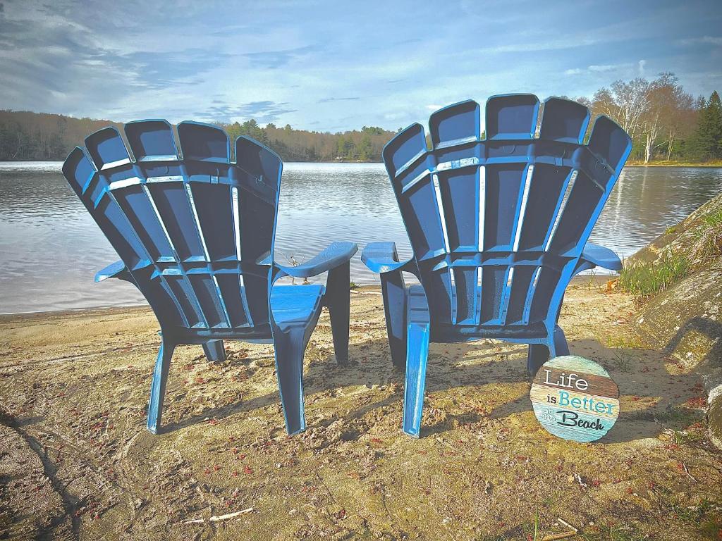 twee blauwe stoelen naast een lichaam water bij Great Escape! (WATERFRONT Cottage in Muskoka) in Windermere