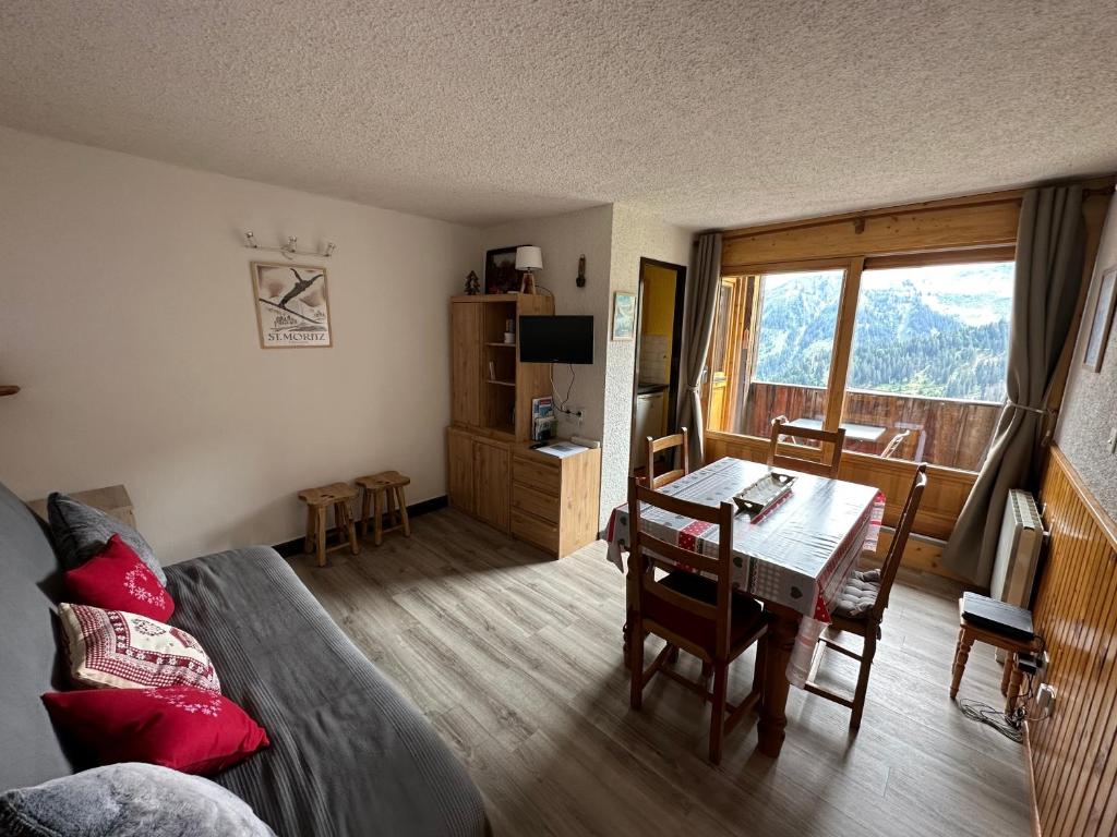 a living room with a table and a room with a view at Arve et Giffre Samoens 1600 in Samoëns