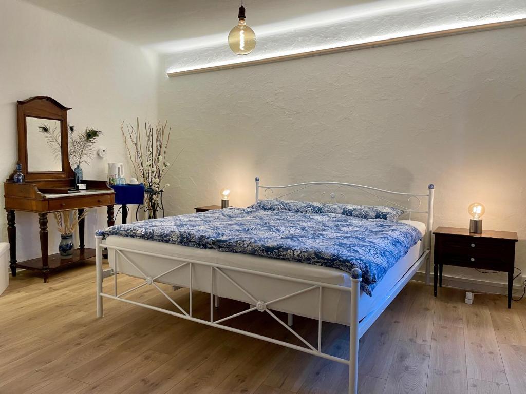 een slaapkamer met een bed met een blauw dekbed bij 1912 - Blue Room - old town in Locarno