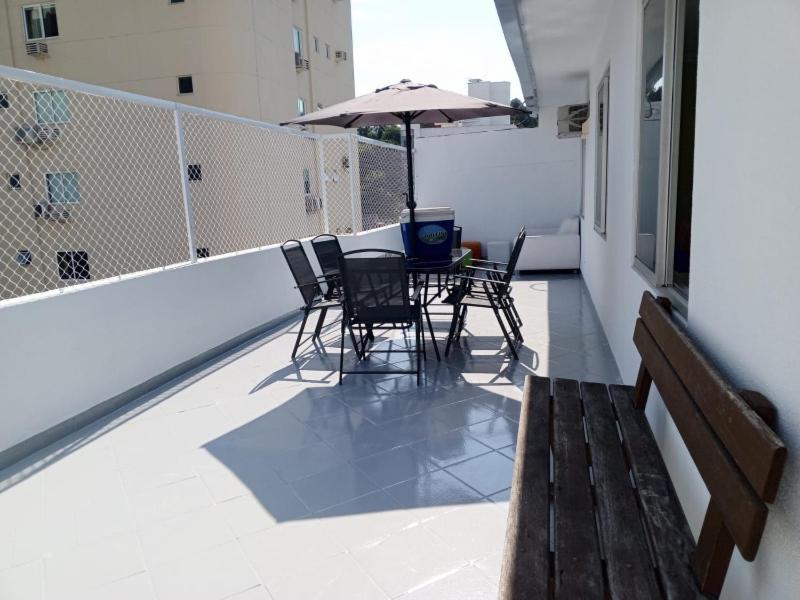 a balcony with a table and chairs and an umbrella at Apartamento cobertura em balneário Camboriú in Balneário Camboriú