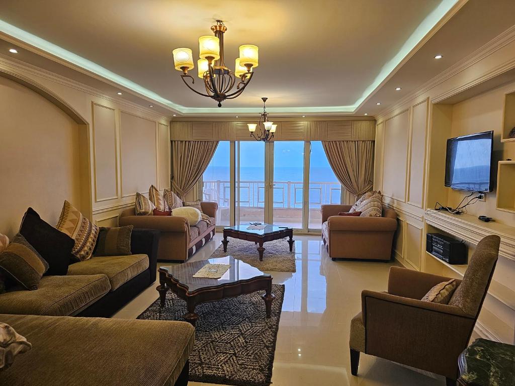 a living room with couches and a flat screen tv at Welcome sea view - families only in Alexandria