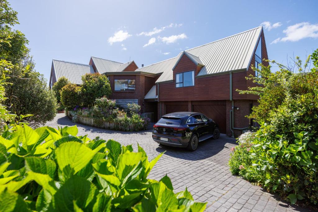 un coche aparcado frente a una casa en Absolute Beachfront Luxury Accommodation, en Paraparaumu