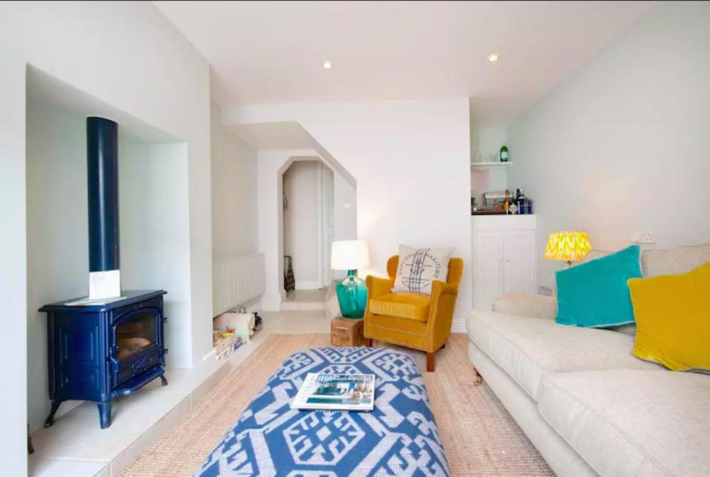 uma sala de estar com um sofá branco e uma lareira em The Boat House em Aldeburgh