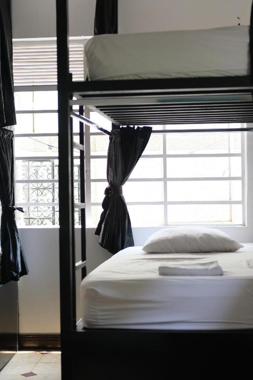 Rúm í herbergi á La Palmera Hostel