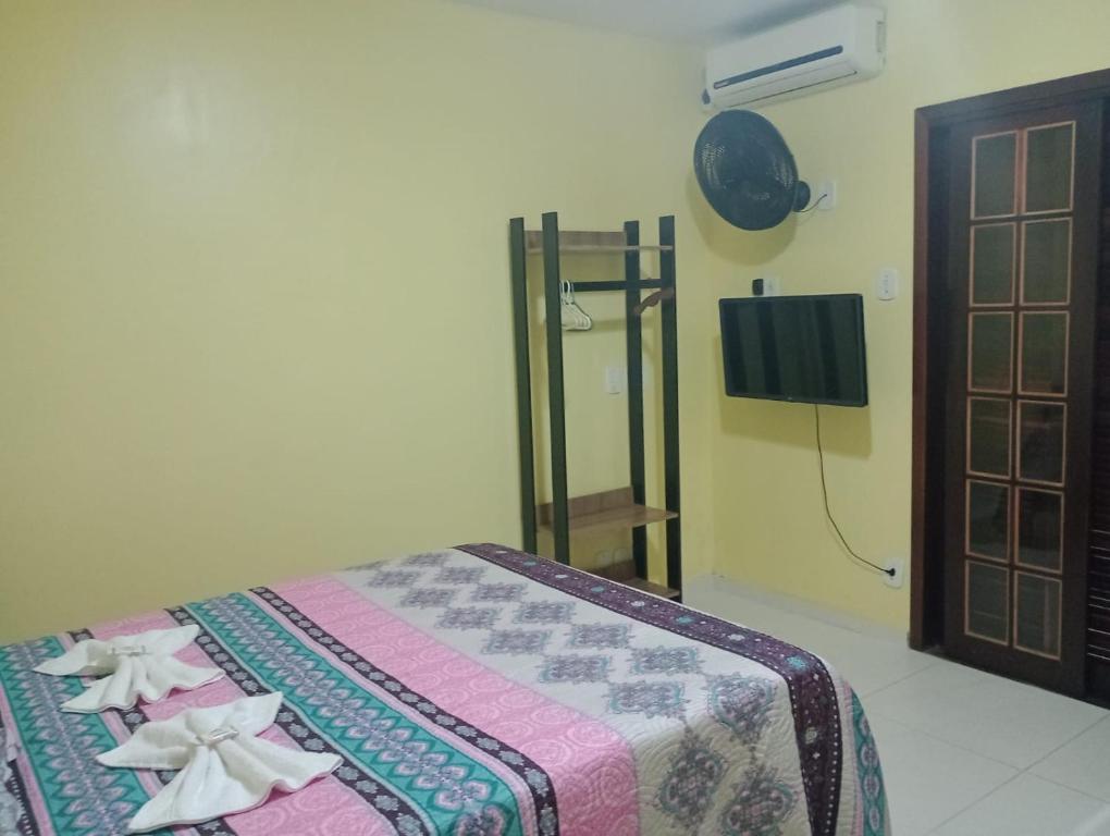 ein Schlafzimmer mit einem Bett mit Blumen darauf in der Unterkunft CASA DA BARRA- Suítes privativas em Saquarema in Saquarema
