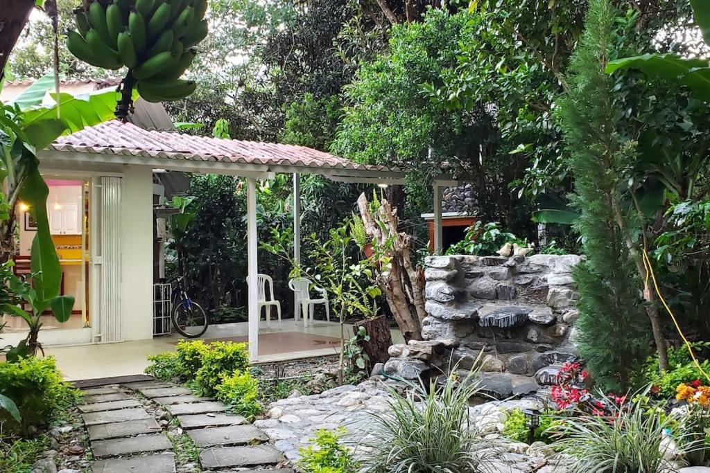 Casa pequeña con un camino de piedra que conduce a un jardín en Casa vacacional ideal para familias / Los Reyes, en Loja