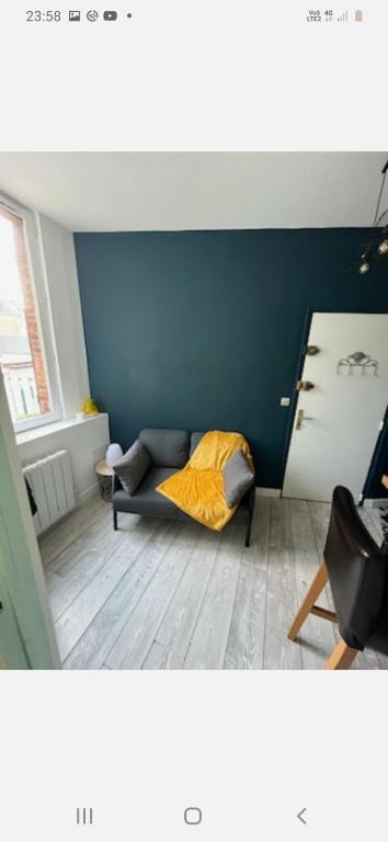 une chambre avec un lit et un mur bleu dans l'établissement T2 proche gare avec wifi, à Chartres