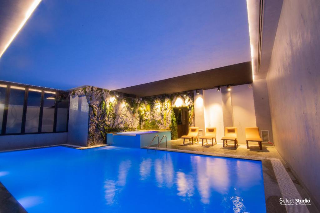 una piscina en un edificio con sillas alrededor en Hotel Kocibelli POOL & SPA, en Korçë