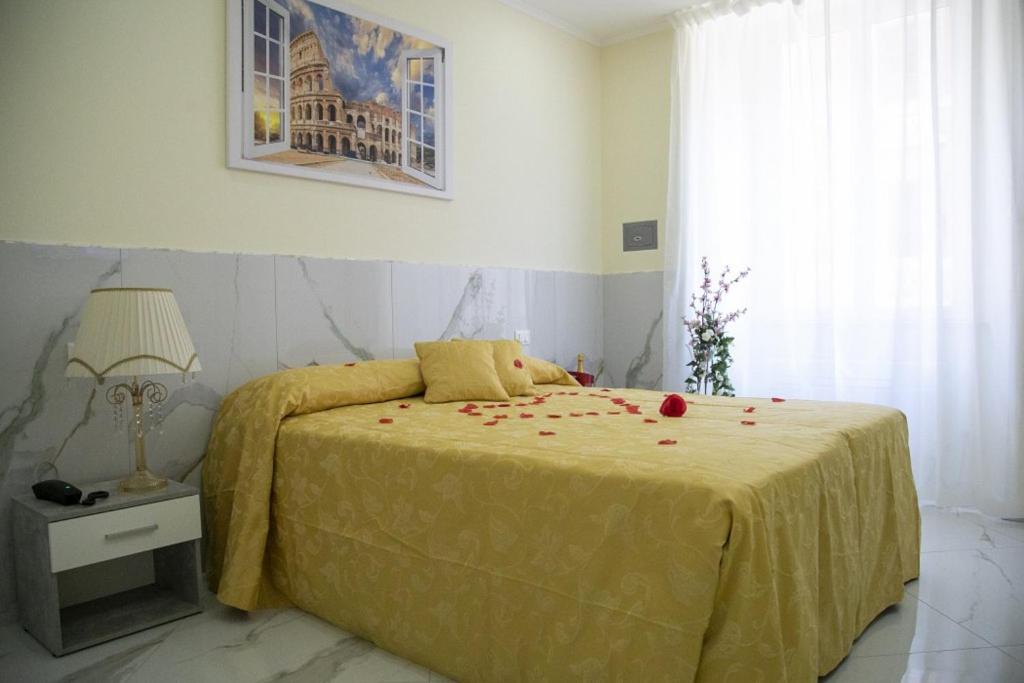 a bedroom with a bed with red rose petals on it at NINFA in Rome